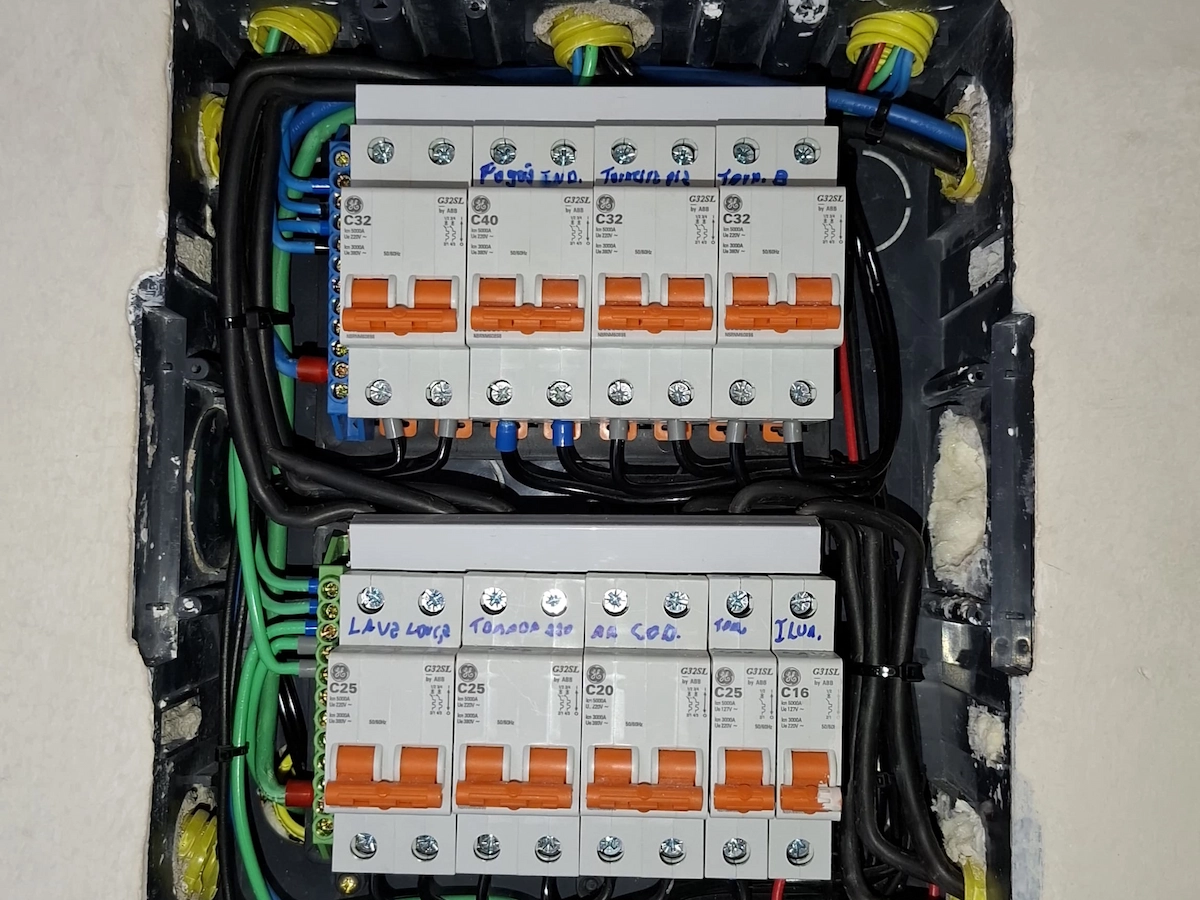 Eletricista profissional trabalhando em quadro de distribuição elétrica